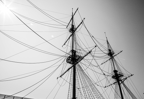 Patterned masts of the ship with folded sails, black and white photograph.