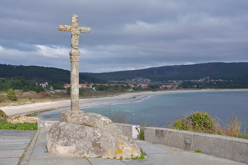 Bonneval-sur-Arc, France - September 18, 2022: Wooden cucified Christ. In the background, the Levanne and the glacier of sources of the Arc river.