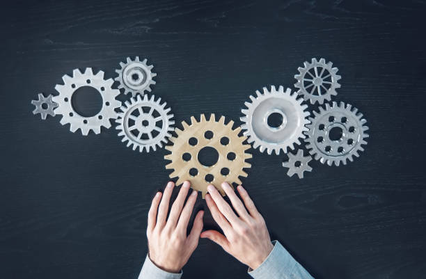 istock Man hands putting a cogwheel into a common mechanism. 1650285993