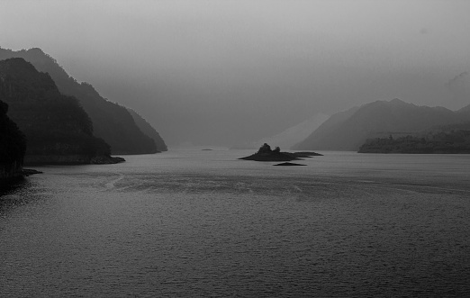 Atmosphere, rivers, mountains, lakes, sunlight, morning mist before the beautiful sunrise in the countryside (Khao Laem Dam) is a black and white picture, sepia, retrospective.