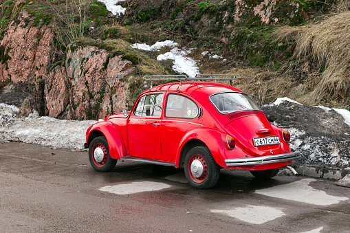 Vyborg, Russia - April 15, 2023: Vintage red Volkswagen Kafer stands on a roadside, rear view