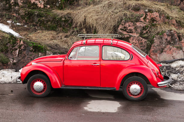 Vyborg, Russia - April 15, 2023: Vintage red Volkswagen Kafer stands on a roadside, side view