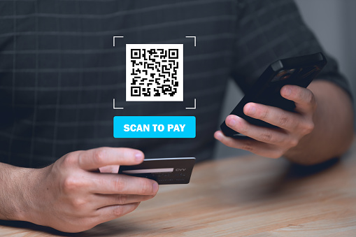 Mobile bill payment barcode scan concept.Man hands using mobile phone and holding bills