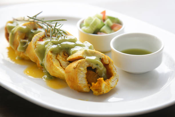 Stuffed chicken rolls served with sauce and vegetables on the resturant table