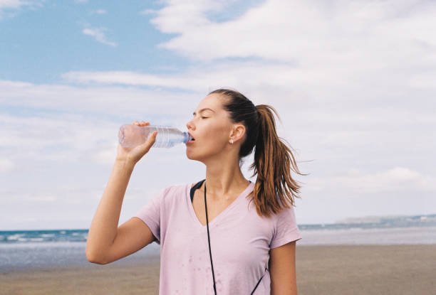 istock Woman drinking water on a beach, 35mm 1650355692