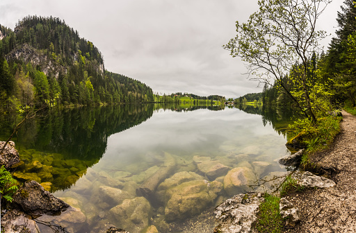 huge rocks in a mountain lake with wonderful reflections from the landscape panorama view