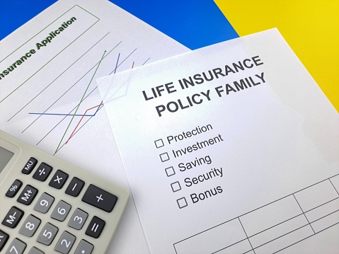Life insurance documents. Insurance documents on a desk with calculator and notepad.