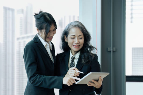 istock Two happy diverse coworker discussing report financial on tablet, working on project together 1650418863
