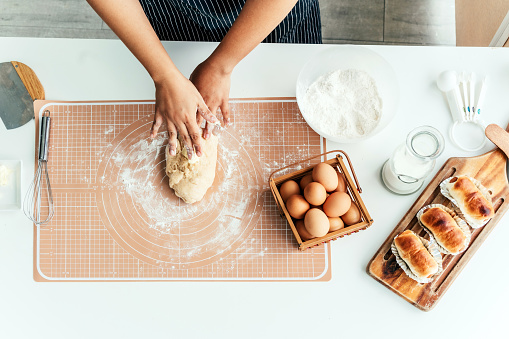 Top view of female hand making bread in kitchen
