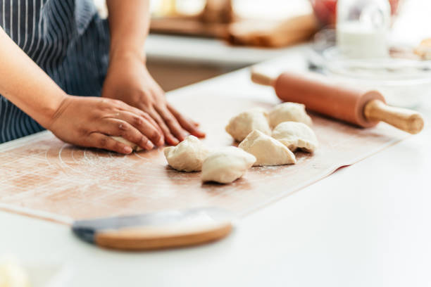 Female pastry chef prepares bread dough in bread kitchen
