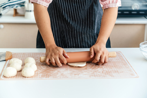Hands of female pastry chef forming bread loaf in bread kitchen