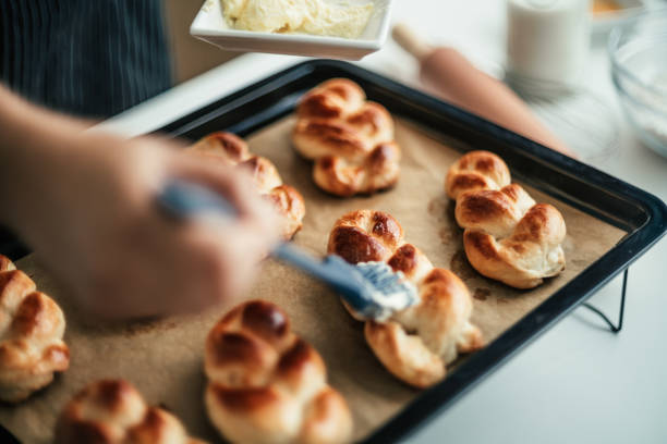 Female baker spreading bread with  buttered in bread kitchen