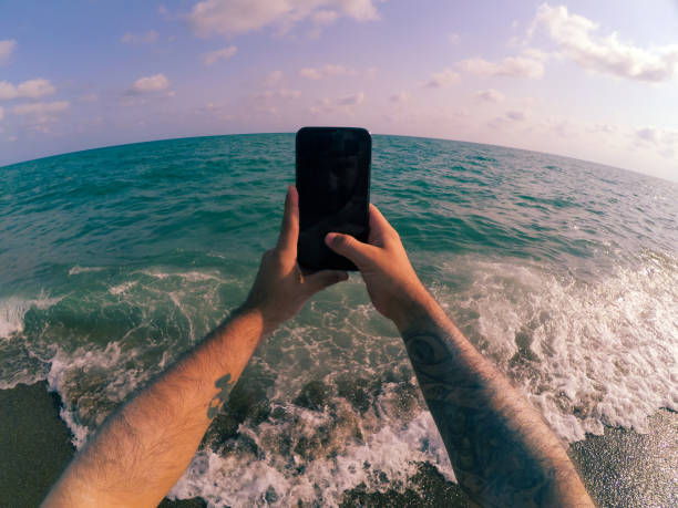istock A man by the sea spends time with his smartphone 1650443868