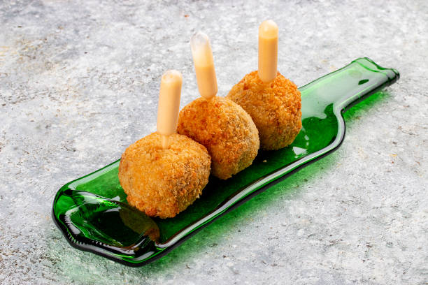 istock Cheese balls deep-fried with white sauce on a decorative plate. Isolated image on a gray background. 1650456718
