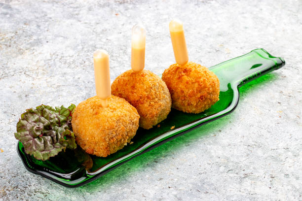 istock Cheese balls deep-fried with white sauce on a decorative plate. Isolated image on a gray background. 1650456727