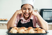 Happy baker looking at some burnt bread after making a mistake with the oven
