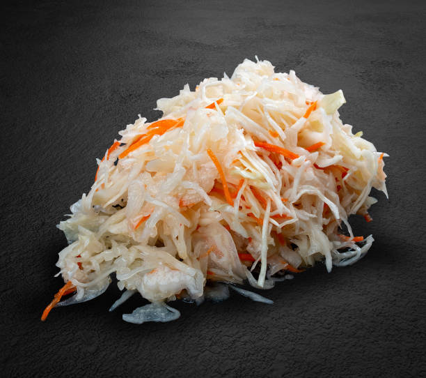 istock Sauteed white cabbage with carrots handmade pickles on a dark stone background. 1650464844