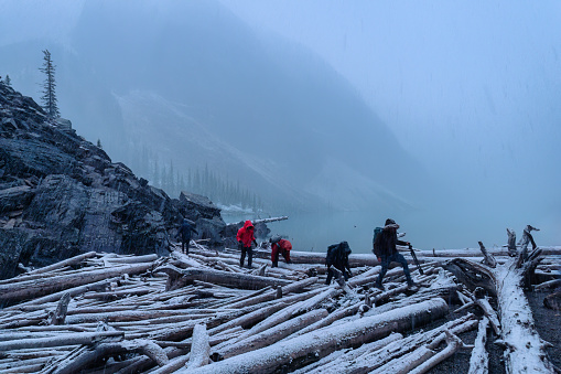 Group of backpacker victims walking through on snowy log wood in blizzard at national park