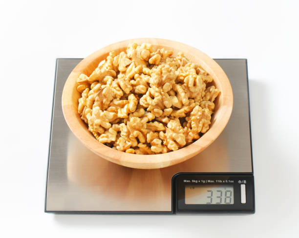 istock bowl of walnuts on a digital scale 165051127