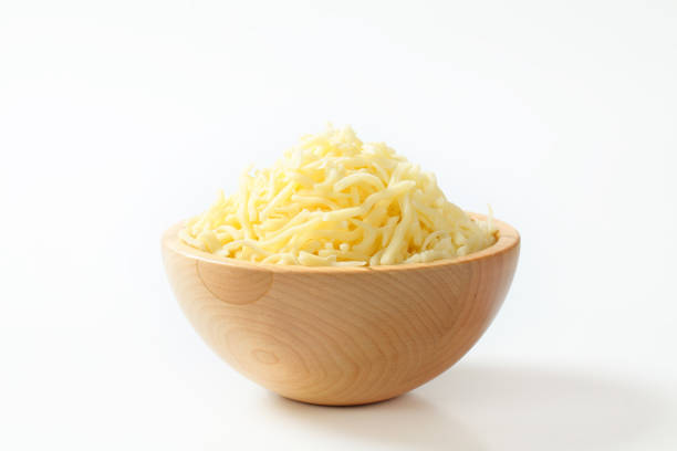 Wooden bowl with grated cheese on white background