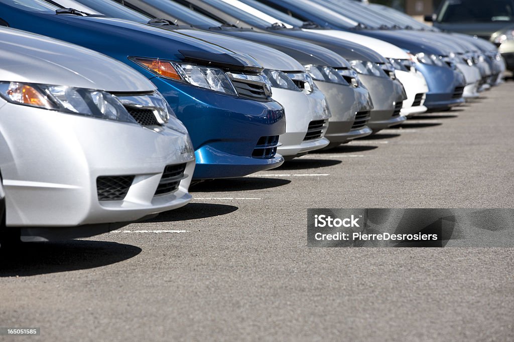 Line of new compact cars at dealership. Lineup of new fuel efficient compact cars in dealership's parking lot, narrow depth of field. Car Stock Photo