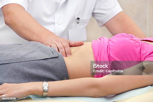 Doctor Testing Stomach Of Young Woman Stock Photo - Download Image Now - Gastroenterologist, Abdomen, Medical Exam