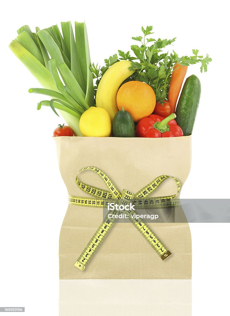 Healthy diet Fresh vegetables and fruits in a paper grocery bag with measuring tape Healthy Eating Stock Photo