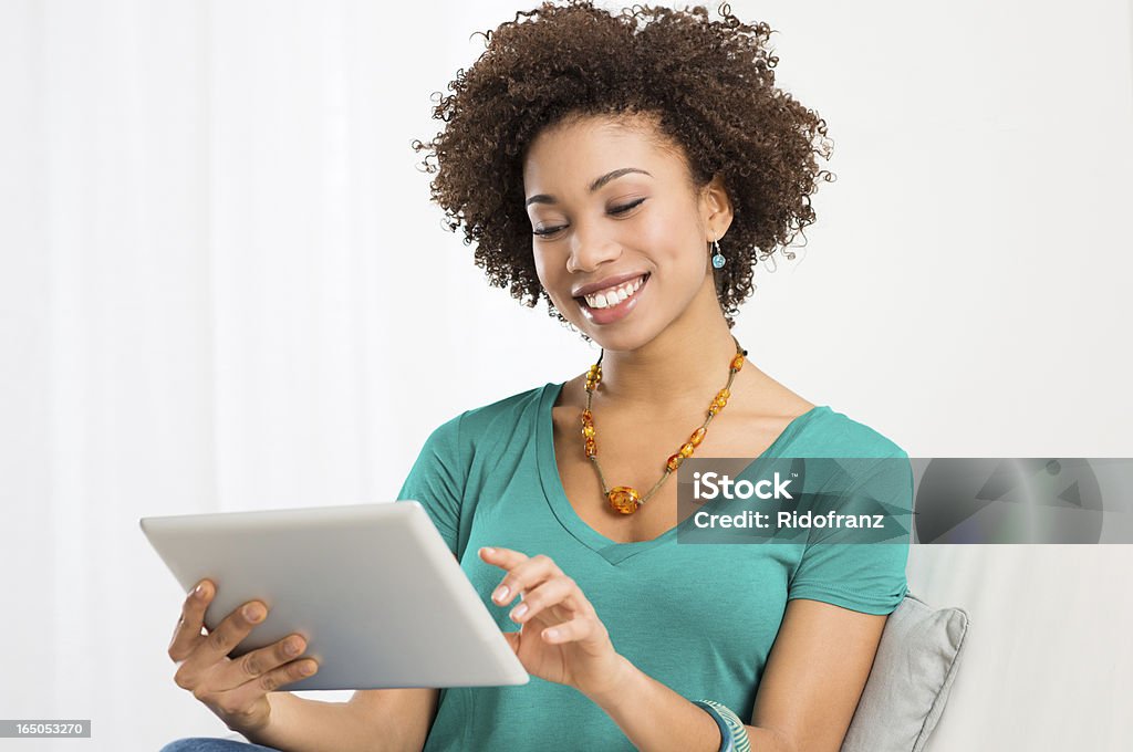 Happy woman using a digital tablet Portrait Of Young Happy African Woman Looking At Digital Tablet Digital Tablet Stock Photo