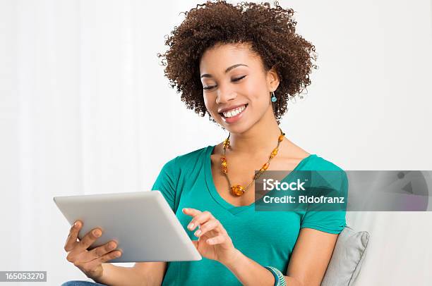 Happy Woman Using A Digital Tablet Stock Photo - Download Image Now - Digital Tablet, Women, Sitting