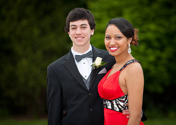 High School Senior Prom Couple Handsom mixed ethnic has their portrait taken outdoors before their high school senior prom. Light rain is falling in the background, romatic! prom photos stock pictures, royalty-free photos & images