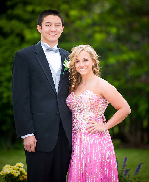 High School Senior Prom Couple Handsome mixed ethnic has their portrait taken outdoors before their high school senior prom. Light rain is falling in the background, romatic! prom dress stock pictures, royalty-free photos & images