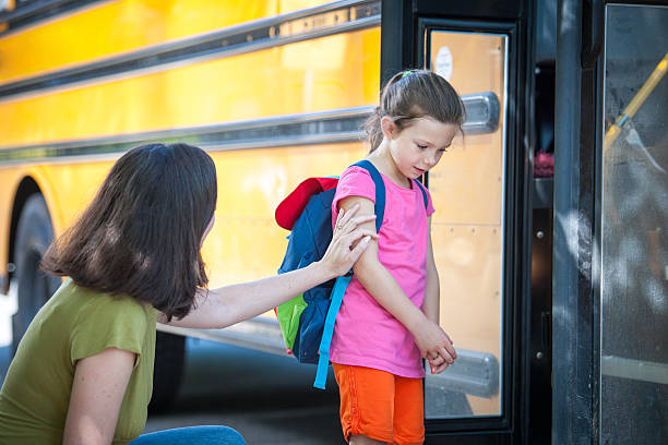 School Bus Series - Timid about Saying Goodbye One of a series of First Day of School images, showing a young girl going through the emotions of getting on the bus for the first time.  shy stock pictures, royalty-free photos & images