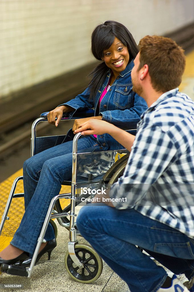 Positive pour personnes à mobilité réduite: Jeune Couple sur le Quai de métro - Photo de Chaise roulante libre de droits