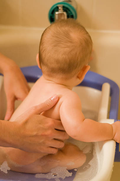 istock Mom bathing baby in special bathtub 165053721