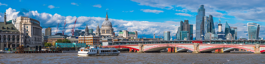 The historic dome of St. Paul’s Cathedral and the futuristic spires of the City financial district skyscrapers overlooking Blackfriars Bridge and the River Thames in the heart of London.