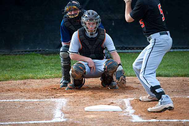 Baseball Catcher Makes the Pitch Call Intense sports image: catcher makes hand signal to the pitcher (viewer), with direct eye contact. This is a crucial pitch and the catcher wants the K. Umpire in standard position looks over shoulder. baseball hand signals stock pictures, royalty-free photos & images