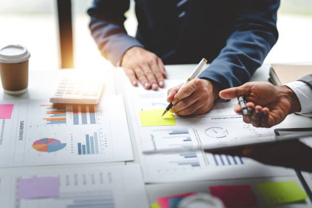 istock Young colleagues discuss business and analytical price charts using calculators and laptops to calculate financial, tax, accounting, statistics and analytical research ideas. 1650569125