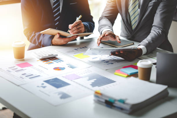 istock Young colleagues discuss business and analytical price charts using calculators and laptops to calculate financial, tax, accounting, statistics and analytical research ideas. 1650569131