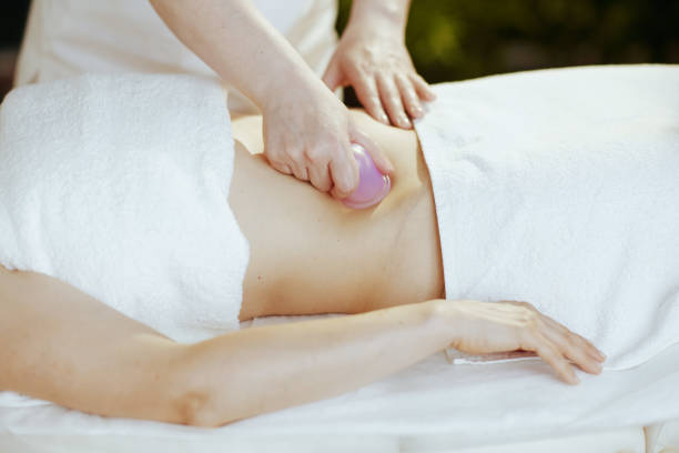 istock Massage therapist in spa salon massaging clients stomach 1650570253