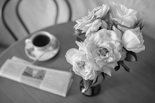 Photography to theme beautiful bouquet roses in vase on wooden table. Photo consisting of bouquet natural roses in vase on wooden table inside the room. Bouquet light roses in vase on wooden table.