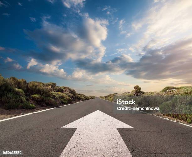 Blue Sky With Clouds And Country Road With White Arrow Stock Photo - Download Image Now
