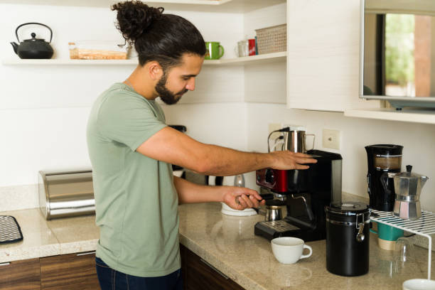 istock Hispanic man using the coffee maker in the kitchen enjoying domestic life 1650653477