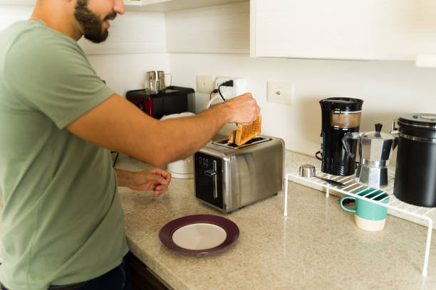 istock Mexican man cooking breakfast using the toaster in the kitchen 1650662225
