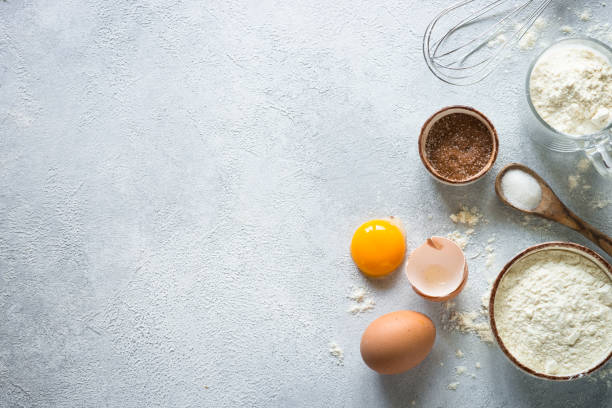 istock Baking background ingredients. Flour, sugar, eggs and rolling pin at light stone table. 1650663879