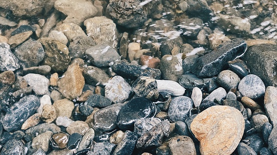 River stones in the river water. Pebbles under water. The view from the top. Nautical background. Clean river water. Transparent river