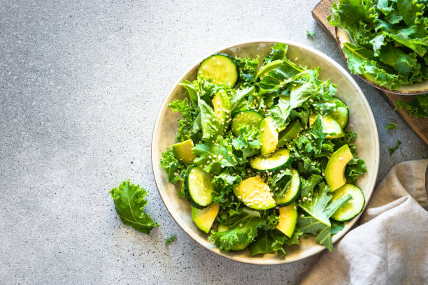 istock Kale salad leaves in craft plate top view. 1650675170