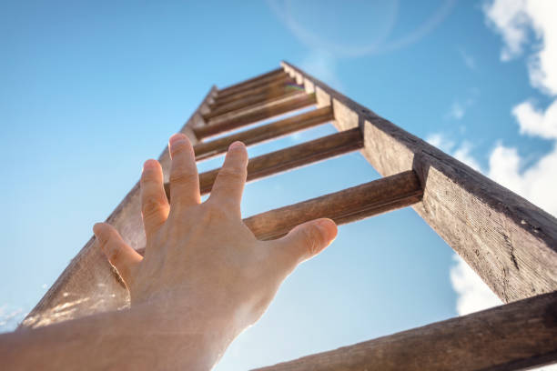 istock Hand reaching for ladder of success 1650675671