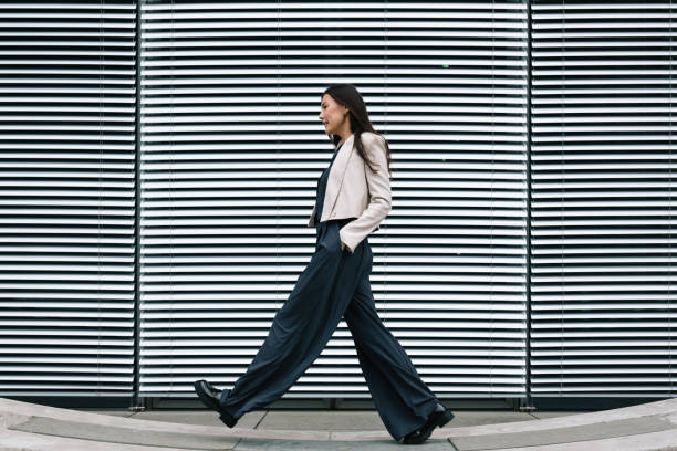 istock confident young woman walks in front of modern architecture 1650681871