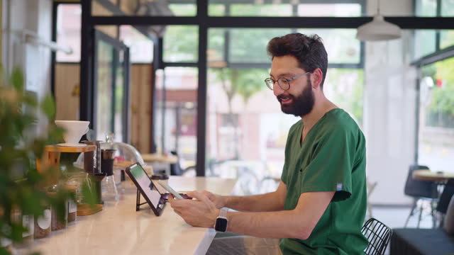 Healthcare worker using digital tablet at a coffee shop