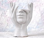 on a white, concrete background - a white plaster figurine without a head with a sense of thoughtfulness. high quality photo